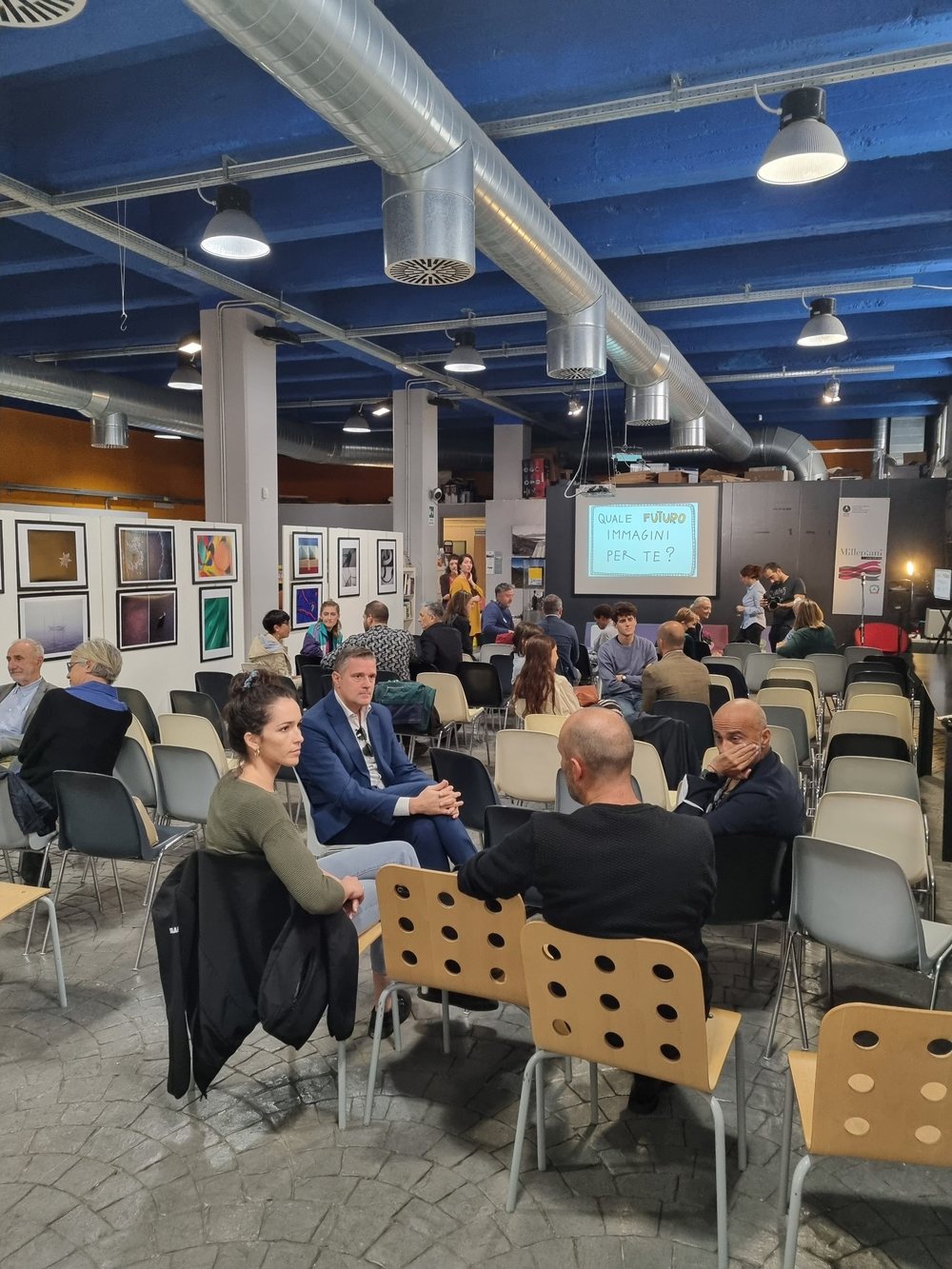 Persone sedute al coworking Millepiani durante AssembraMenti Lazio, davanti allo schermo con la domanda Quale futuro immagini per te?